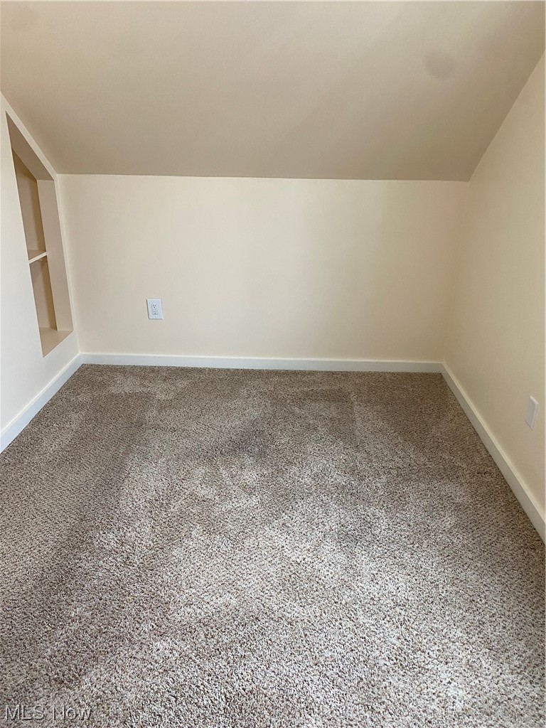 5680 Shawnee Road Cleveland, OH 44124 - Photo 16 of 21 Carpeted spare room with built in shelves and lofted ceiling
