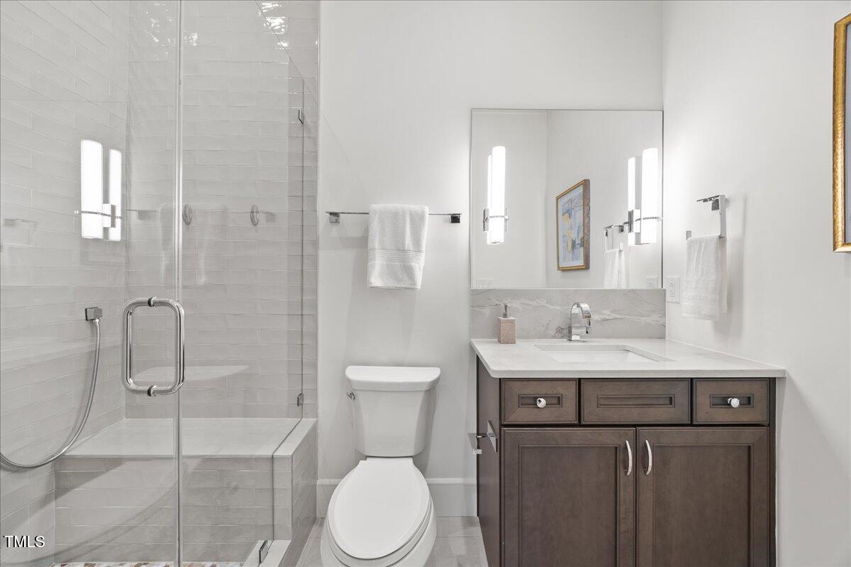 2120 Kipawa Street Raleigh, NC 27607 - Photo 27 of 77 a bathroom with a granite countertop sink a toilet and a mirror