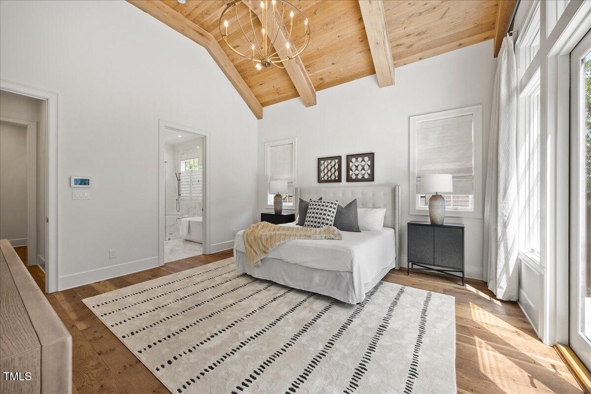 2120 Kipawa Street Raleigh, NC 27607 - Photo 36 of 77 a spacious bedroom with a bed and a chandelier