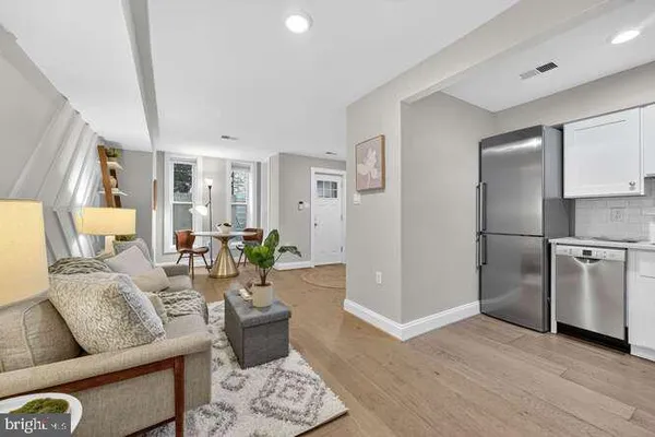 a living room with furniture and a refrigerator