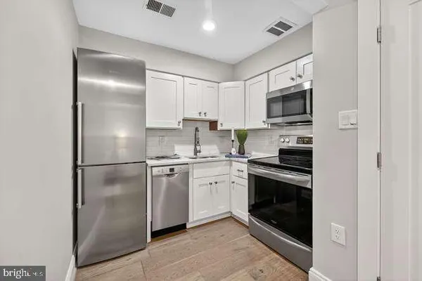 a kitchen with cabinets stainless steel appliances and a counter space