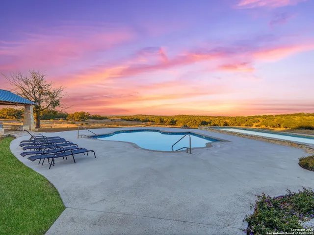 an aerial view of a house with pool and a yard