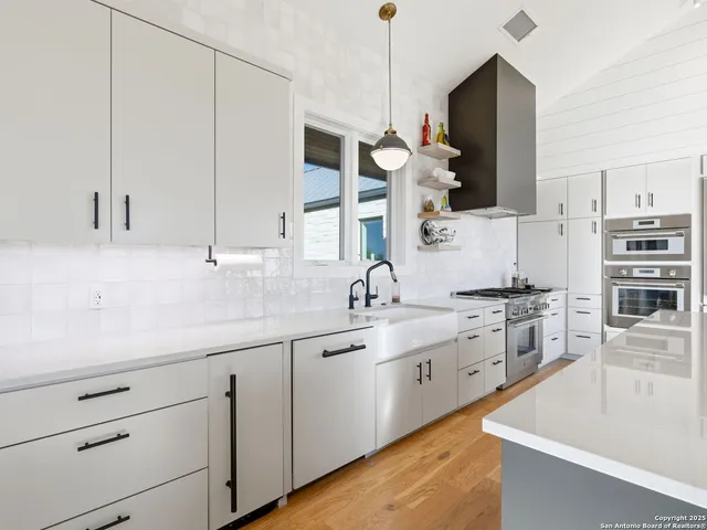 a kitchen with stainless steel appliances granite countertop a stove a sink and a microwave