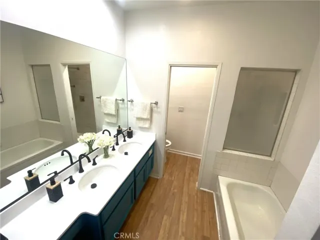 a spacious bedroom with a bed and wooden floor