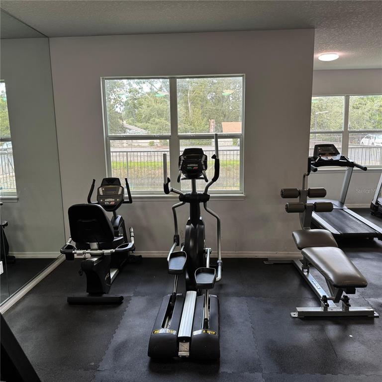 2121 McCoy Road, Unit 302 Orlando, FL 32809 - Photo 4 of 26 a room with gym equipment and a large window