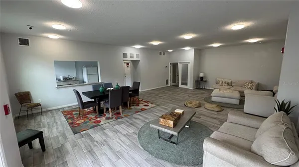 a living room with furniture a dining table and a potted plant