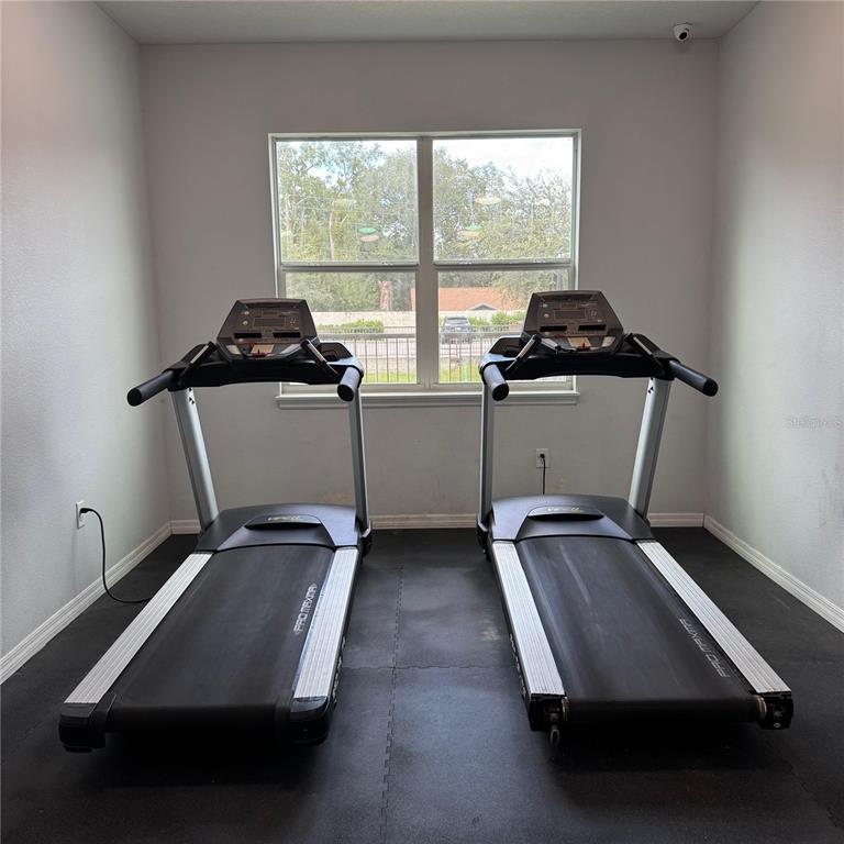 2121 McCoy Road, Unit 302 Orlando, FL 32809 - Photo 8 of 26 a room with gym equipment and a window