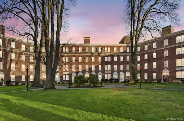 a view of a big building with a big yard and plants