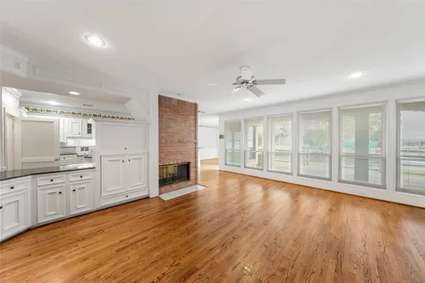 a view of an empty room with a kitchen and wooden floor