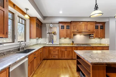 a kitchen with stainless steel appliances granite countertop a sink stove and cabinets