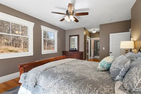 a bedroom with a large bed chandelier and a window
