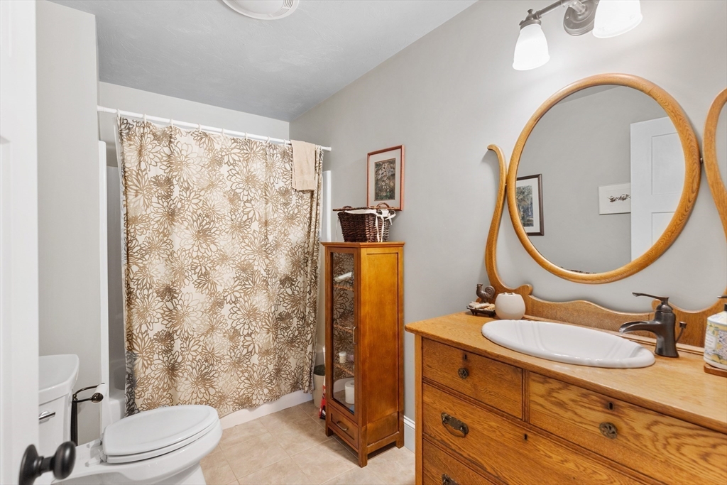 144 Brook Street Hudson, MA 01749 - Photo 25 of 44 a bathroom with a granite countertop sink mirror vanity and a toilet