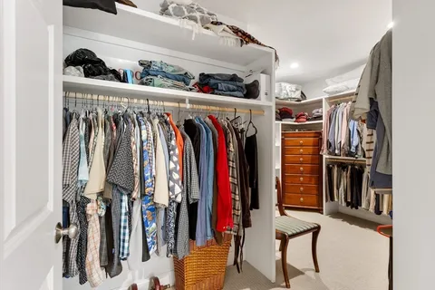 a view of walk in closet with clothes and shoes
