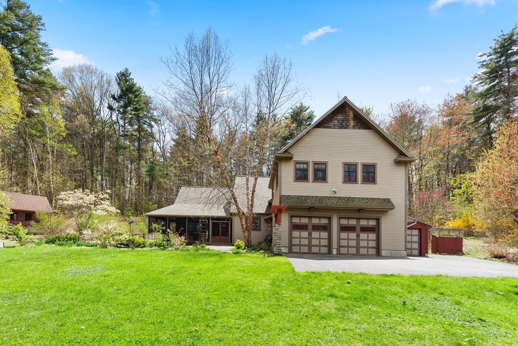 144 Brook Street Hudson, MA 01749 - Photo 35 of 44 a front view of a house with a garden and trees