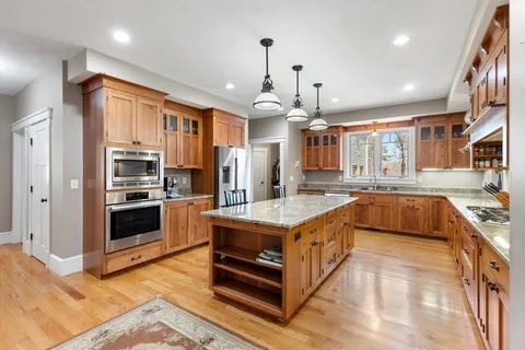 a large kitchen with stainless steel appliances granite countertop a stove and a sink