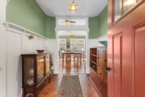a hallway with dining area and chandelier