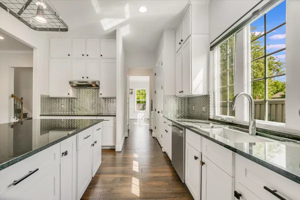 a kitchen with granite countertop a sink and a refrigerator