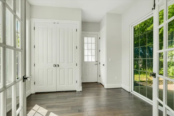 an empty room with wooden floor and windows