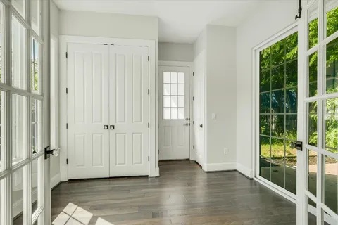 an empty room with wooden floor and windows
