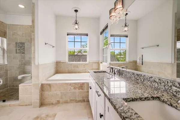 a bathroom with a granite countertop bathtub sink vanity and granite