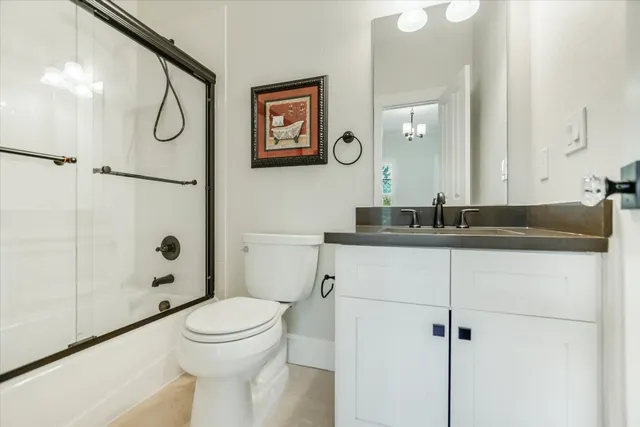 a bathroom with a granite countertop sink mirror vanity and toilet