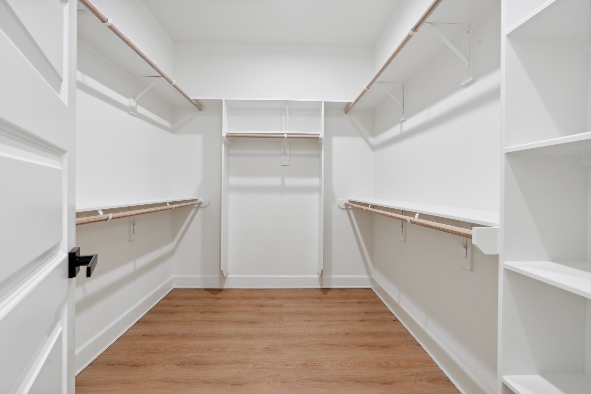 6408 Foster Street Houston, TX 77021 - Photo 23 of 39 Spacious primary walk-in closet — wrap-around hanging rods, shoe shelving towers, and warm oak-look flooring throughout.
