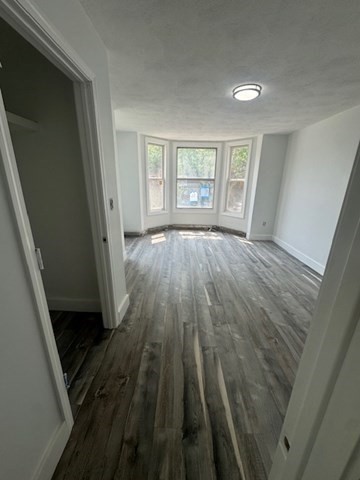 252 East Eagle Street, Unit 2 Boston, MA 02128 - Photo 7 of 11 wooden floor in an empty room with a window
