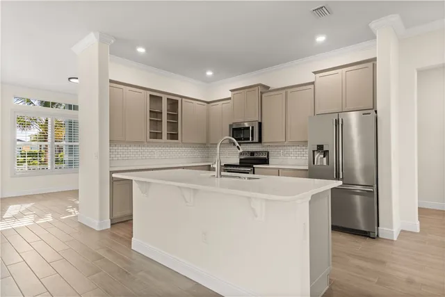 a kitchen with stainless steel appliances a refrigerator sink and cabinets