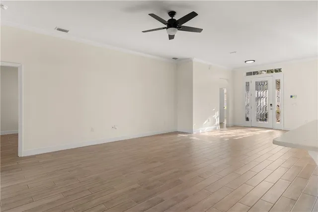 a view of empty room with wooden floor and ceiling fan