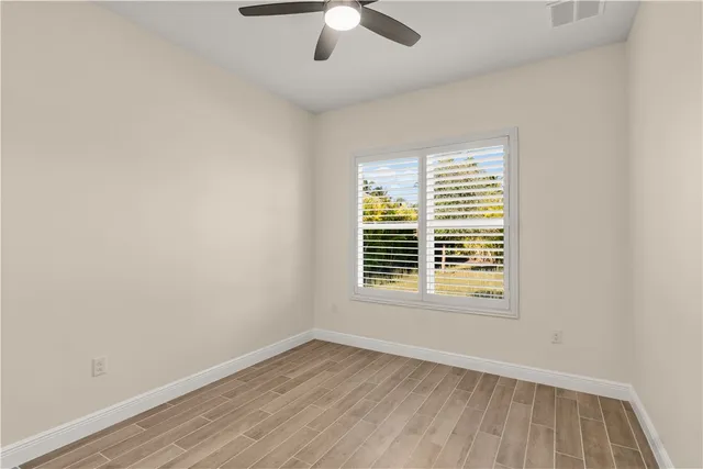 an empty room with a window and wooden floor