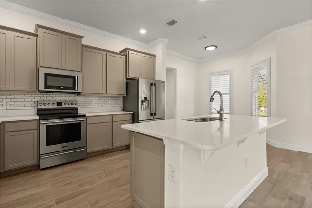 a kitchen with kitchen island a sink appliances and cabinets