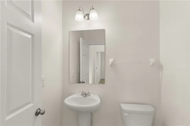 a bathroom with a sink toilet and mirror
