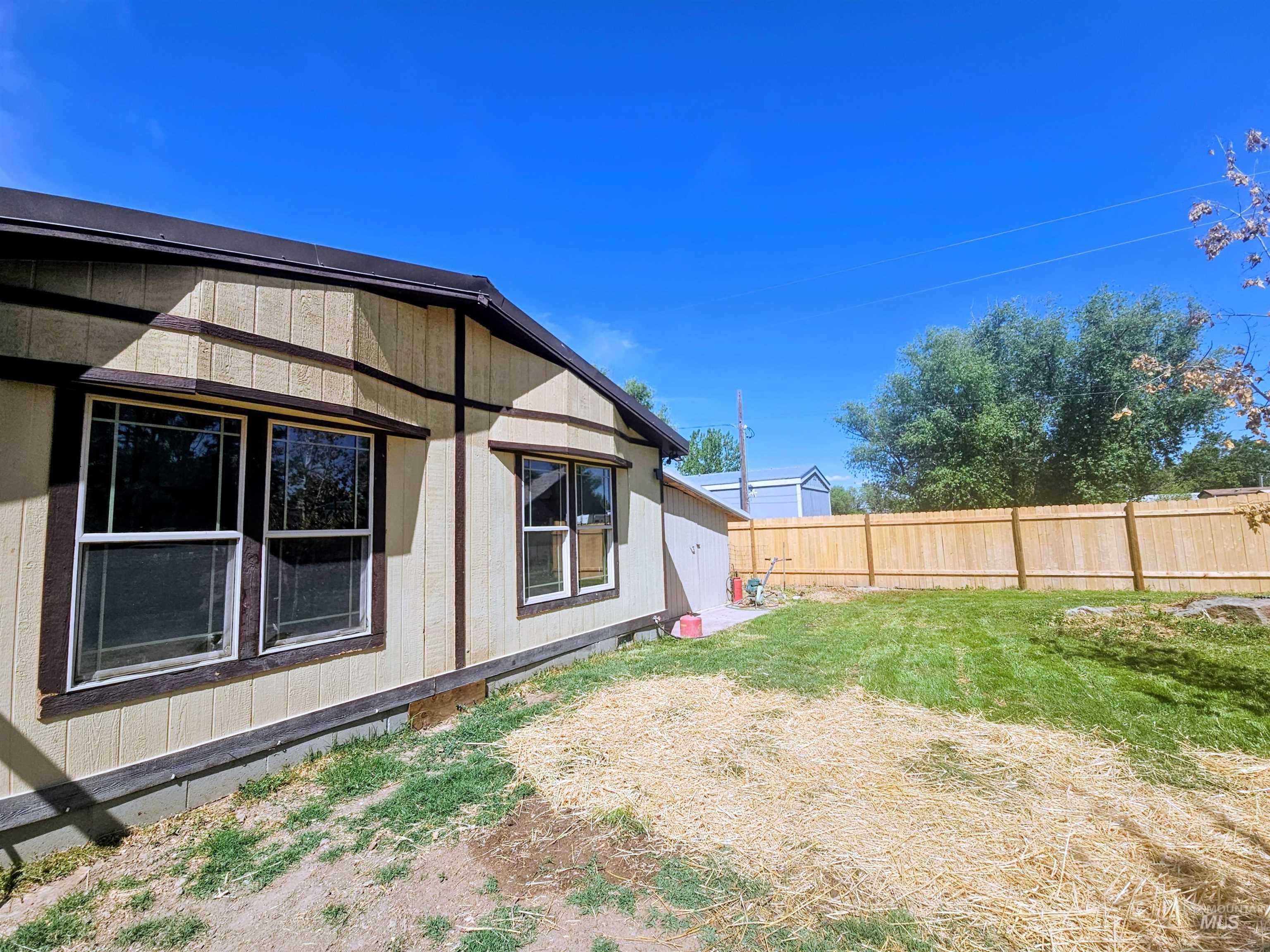 8392 Main Street Letha, ID 83636 - Photo 29 of 31 Exterior siding with contrasting trim, multiple windows, and a wood privacy fence