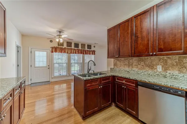 a kitchen with stainless steel appliances granite countertop wooden cabinets and granite counter tops