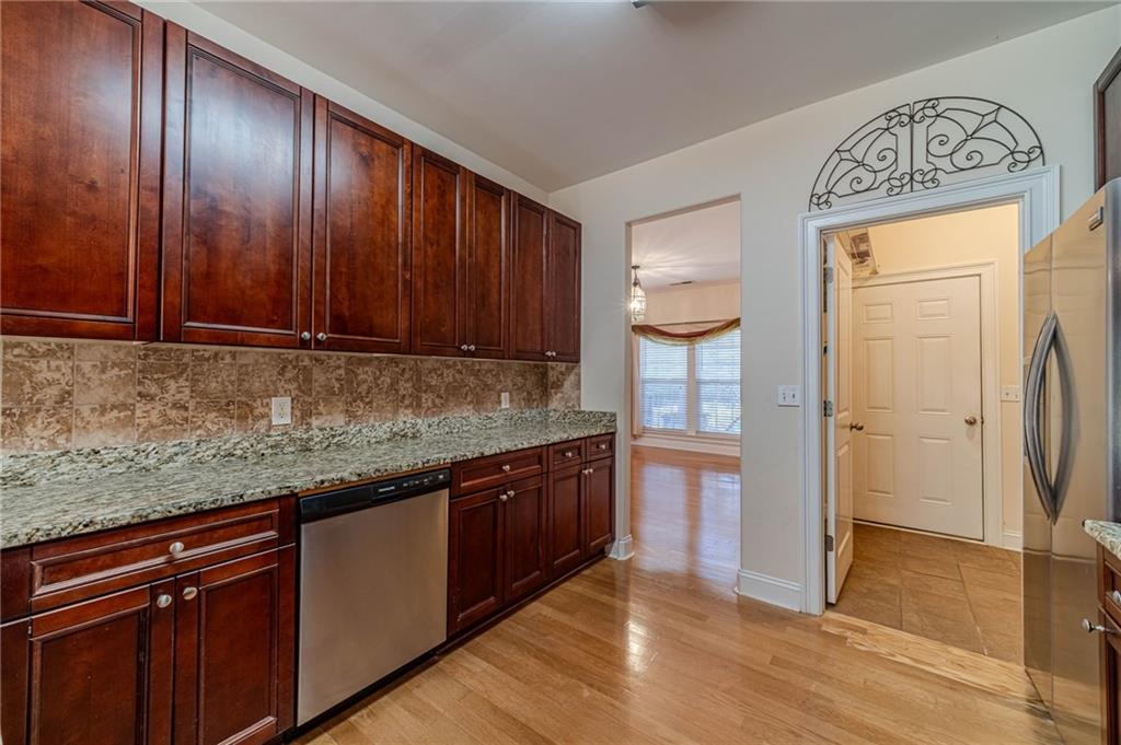654 Huntington Trace Winder, GA 30680 - Photo 15 of 51 a kitchen with stainless steel appliances granite countertop wooden cabinets and granite counter tops