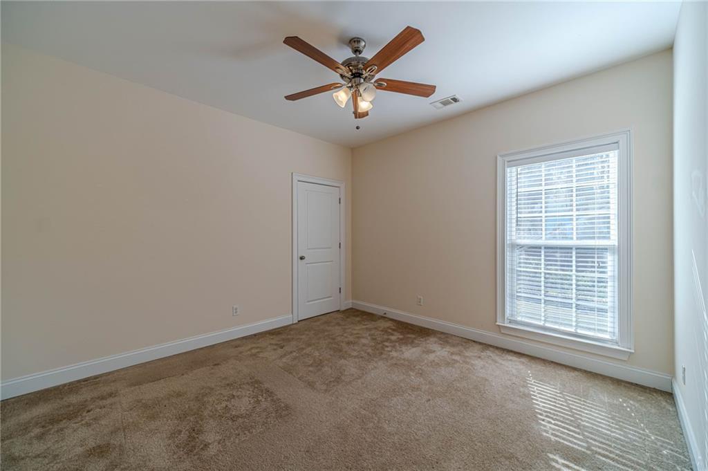 654 Huntington Trace Winder, GA 30680 - Photo 34 of 51 an empty room with closet and ceiling fan
