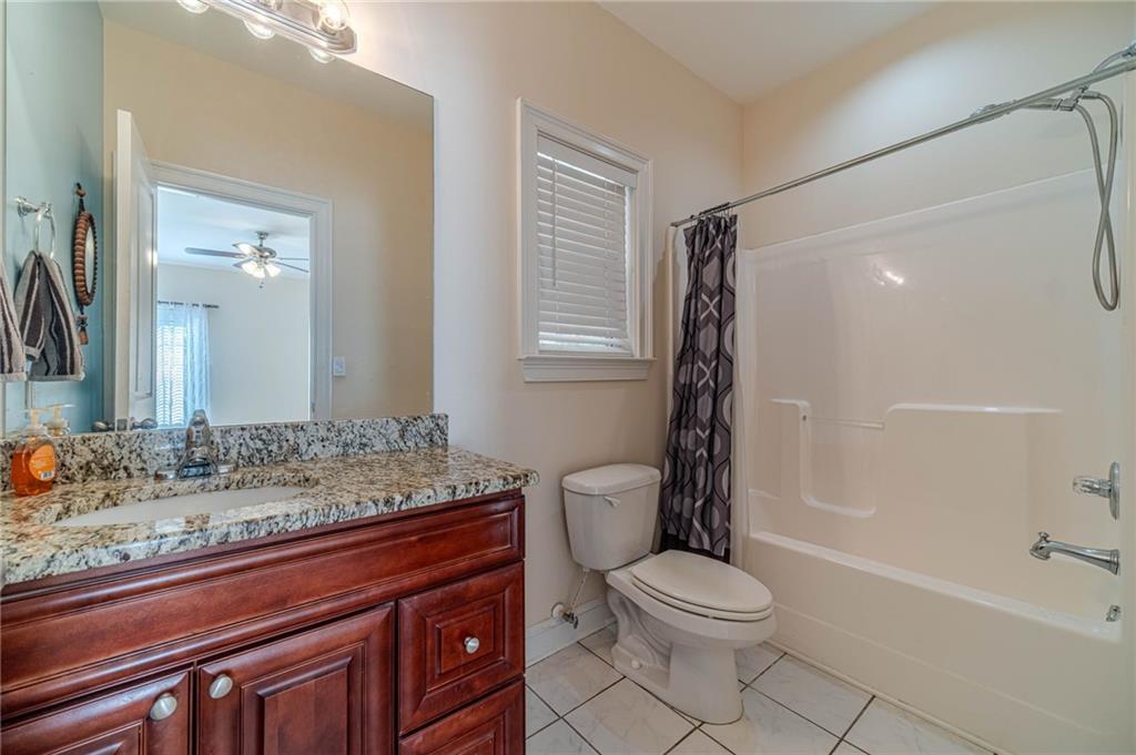 654 Huntington Trace Winder, GA 30680 - Photo 39 of 51 a bathroom with a granite countertop sink toilet mirror and shower