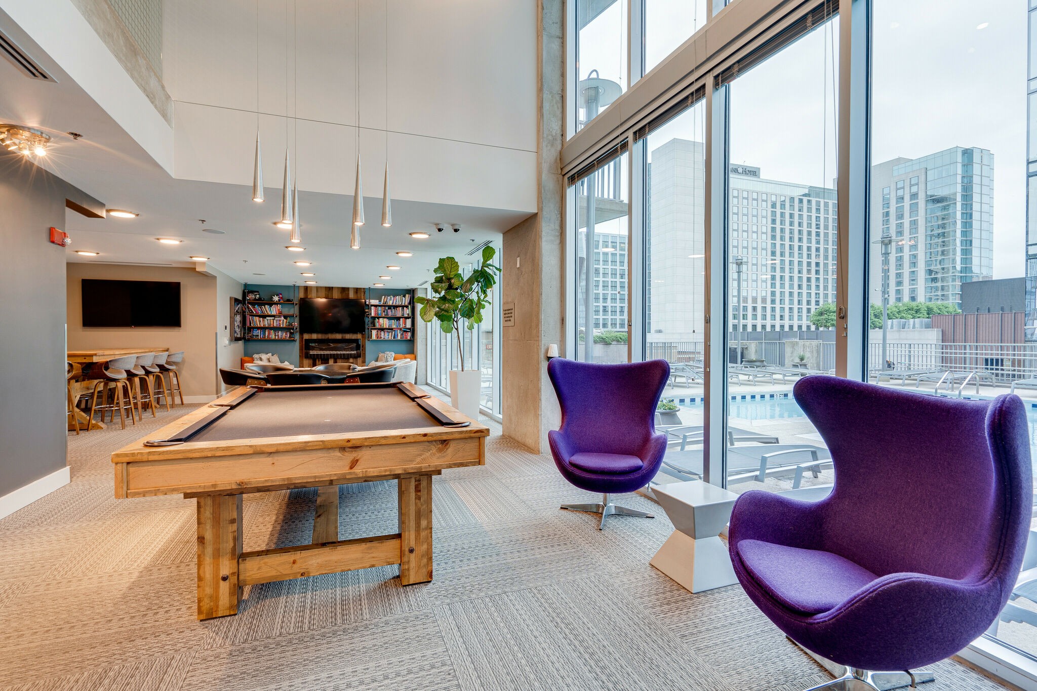 301 Demonbreun Street, Unit 1120 Nashville, TN 37201 - Photo 37 of 51 a living room with furniture a flat screen tv and a floor to ceiling window