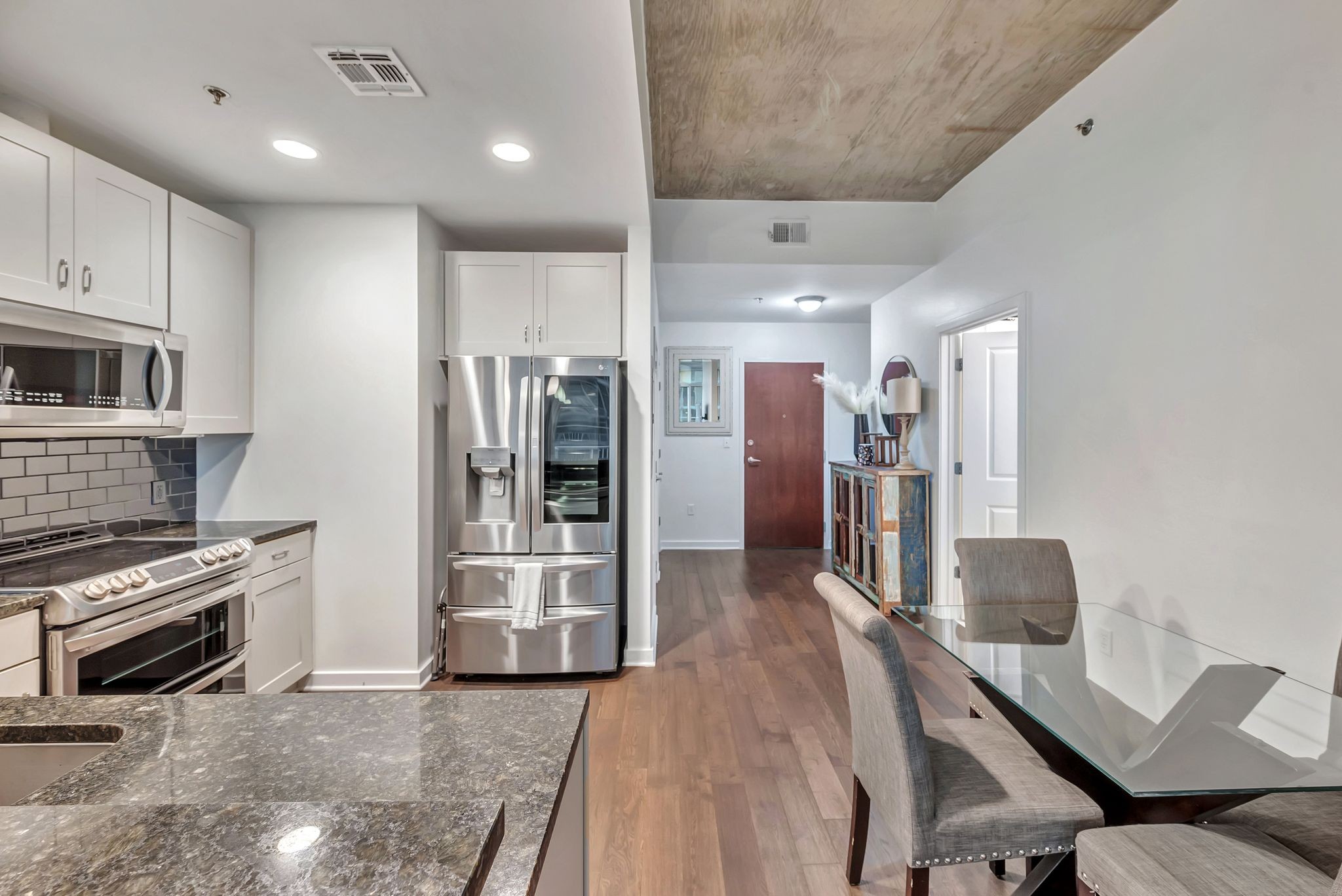 301 Demonbreun Street, Unit 1120 Nashville, TN 37201 - Photo 10 of 51 a kitchen with stainless steel appliances kitchen island granite countertop a refrigerator and a stove top oven