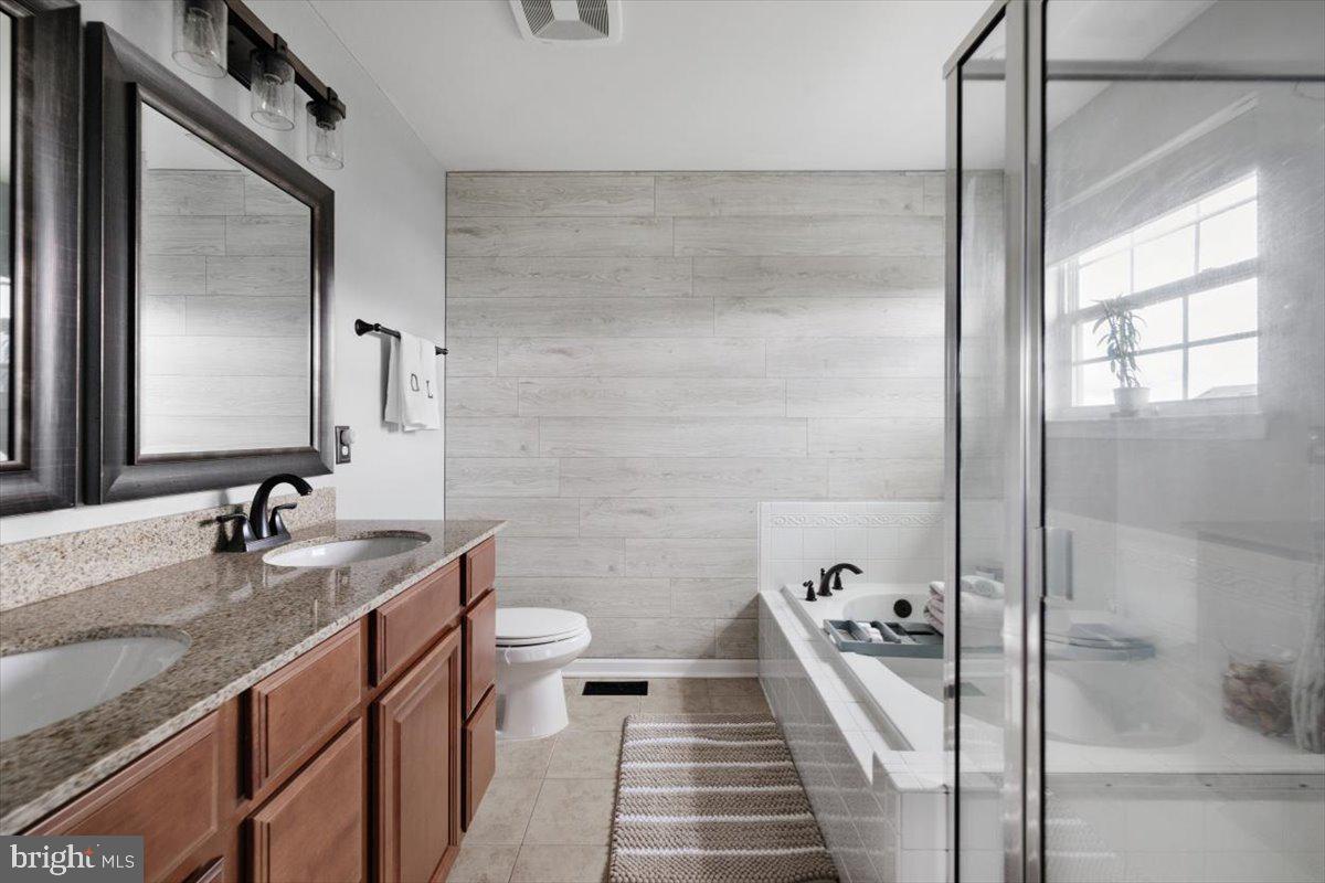 217 Morlyn Drive Stephenson, VA 22656 - Photo 17 of 35 a bathroom with a granite countertop sink a toilet a mirror and shower