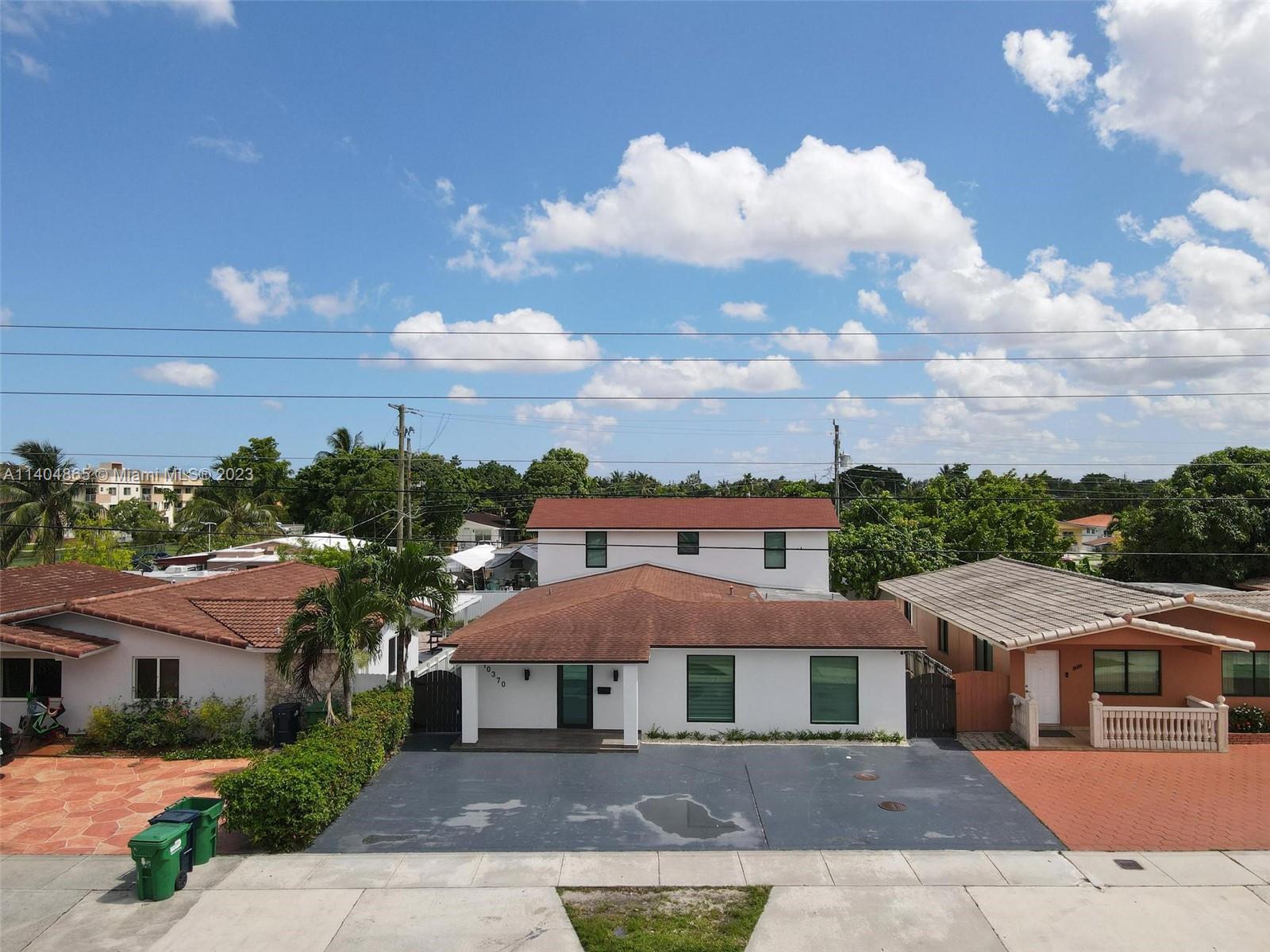 10370 Southwest 24th Street, Unit B Miami, FL 33165 - Photo 8 of 10 a front view of a residential apartment building with a yard