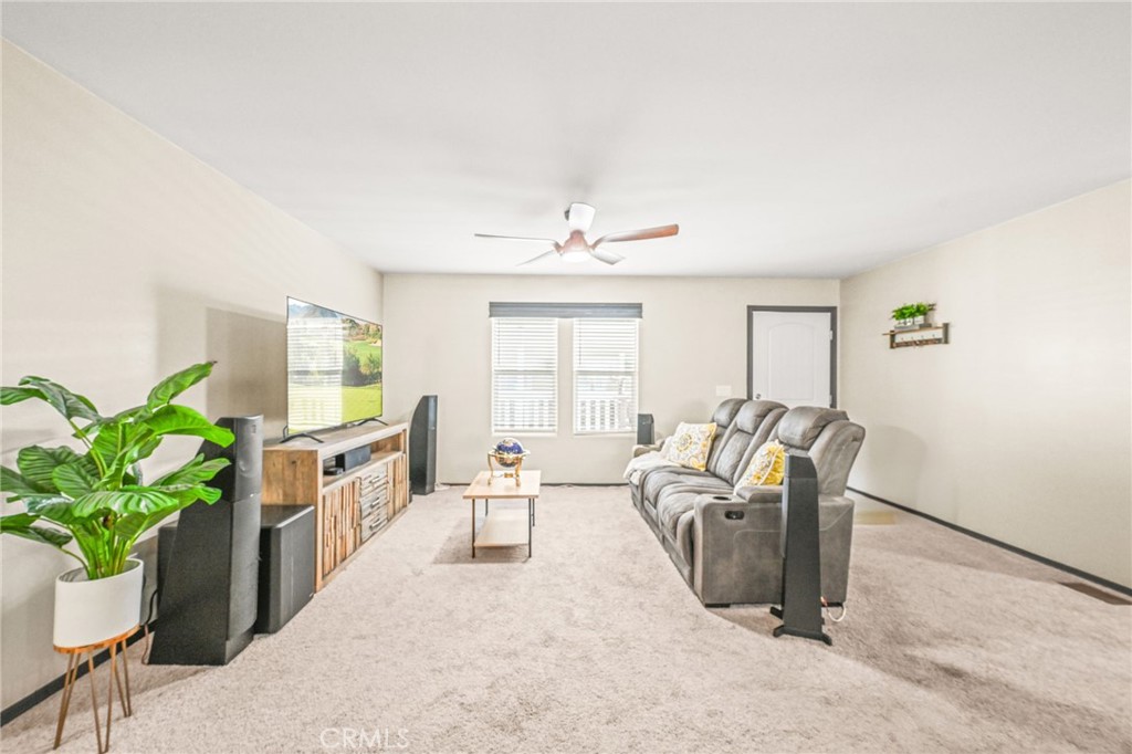 16860 Slover Avenue, Unit 70 Fontana, CA 92337 - Photo 12 of 38 a living room with furniture a chandelier and a potted plant