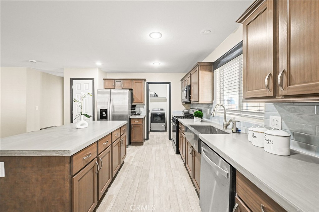 16860 Slover Avenue, Unit 70 Fontana, CA 92337 - Photo 18 of 38 a large kitchen with a large window and stainless steel appliances