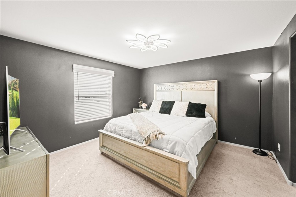 16860 Slover Avenue, Unit 70 Fontana, CA 92337 - Photo 25 of 38 a bedroom with a large bed and a chandelier