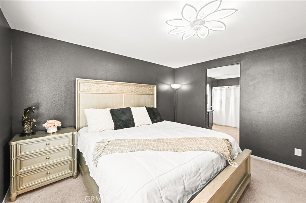 16860 Slover Avenue, Unit 70 Fontana, CA 92337 - Photo 26 of 38 a bedroom with a bed and a chandelier fan