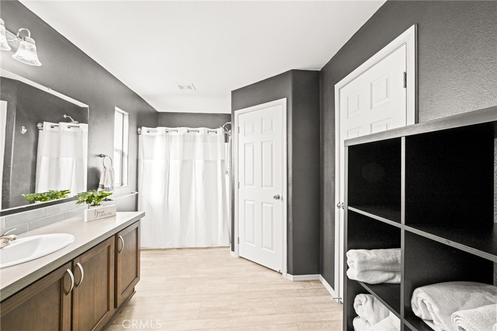 16860 Slover Avenue, Unit 70 Fontana, CA 92337 - Photo 29 of 38 a bathroom with a granite countertop sink and a mirror