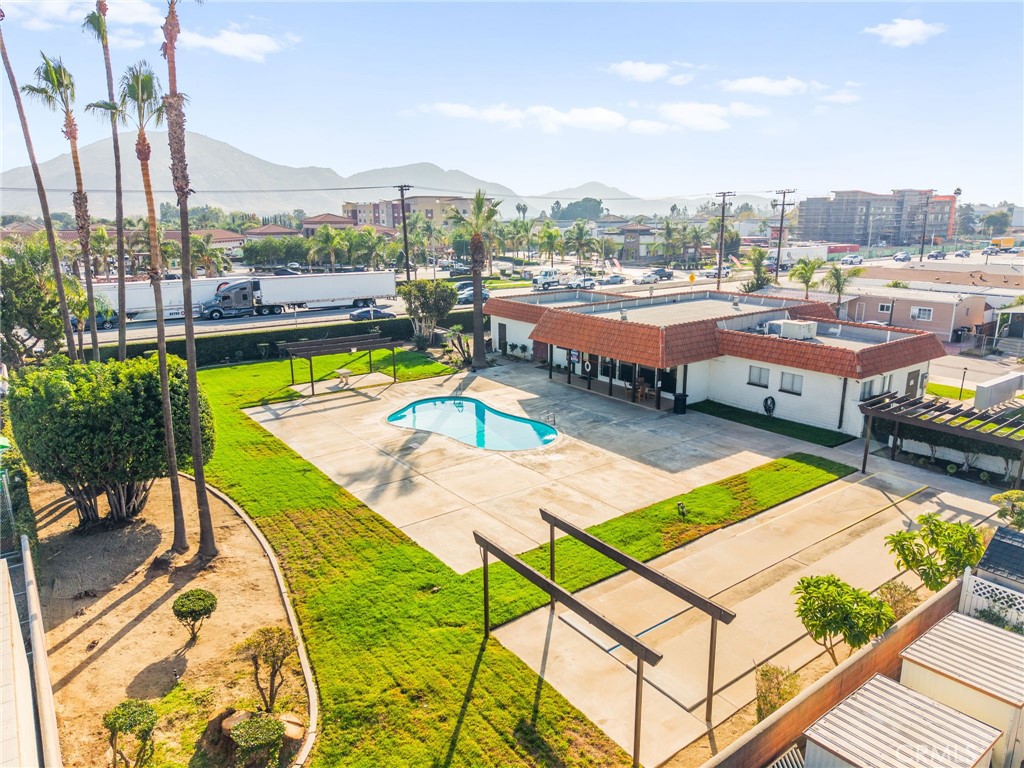 16860 Slover Avenue, Unit 70 Fontana, CA 92337 - Photo 37 of 38 a view of a swimming pool with lawn chairs plants and large trees