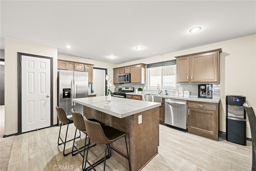 16860 Slover Avenue, Unit 70 Fontana, CA 92337 - Photo 7 of 38 a kitchen with stainless steel appliances a stove a sink dishwasher and a refrigerator