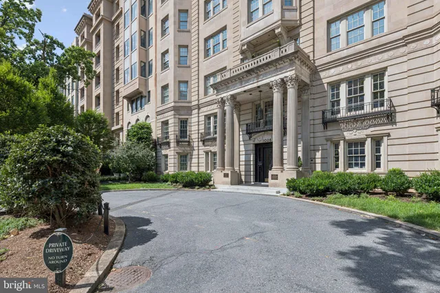 a view of a building with potted plants and a pathway