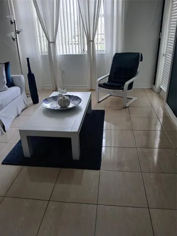 a living room with a table chairs and a window